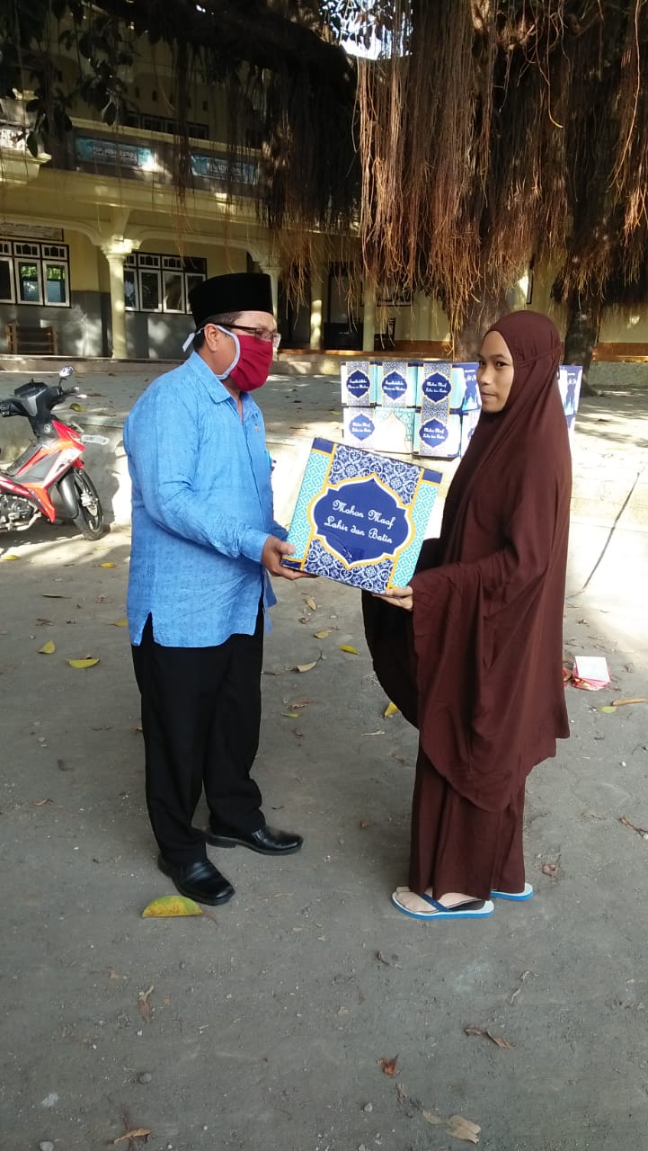 Kepala Dinas Sosial (H. AHMAT A, S. Kep. MM) Menyerahkan Bingkisan Berupa Paket Kepada Salah Satu Santriwati Di Pondok Pesantren Darul Furqon Mengkuru  Desa Mengkuru Kec. Sakra Barat